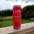Elix Cranberry Sour can on a cedar deck railing